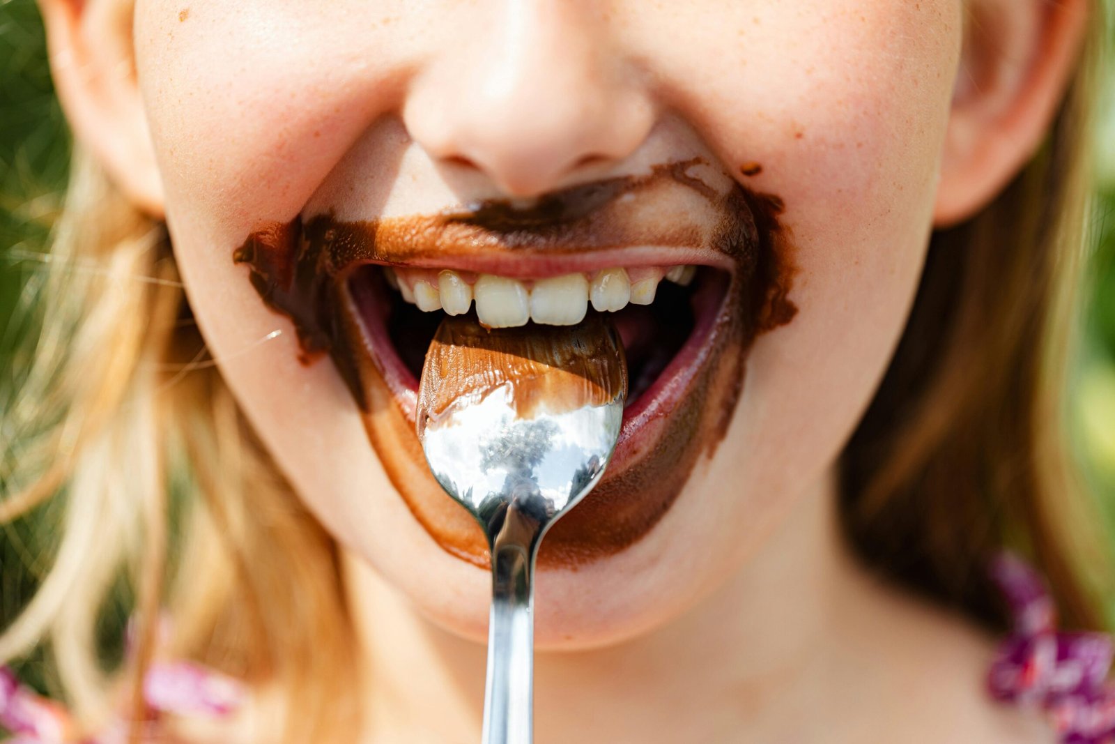 Anak Perempuan Sedang Makan Coklat Penyebab Gigi Berlubang